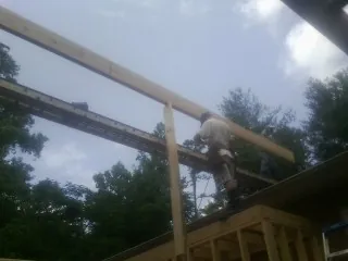 Carpenter setting a ridge beam over a new addition frame — Ice Dam Removal by Roofing Brothers in Wilbur