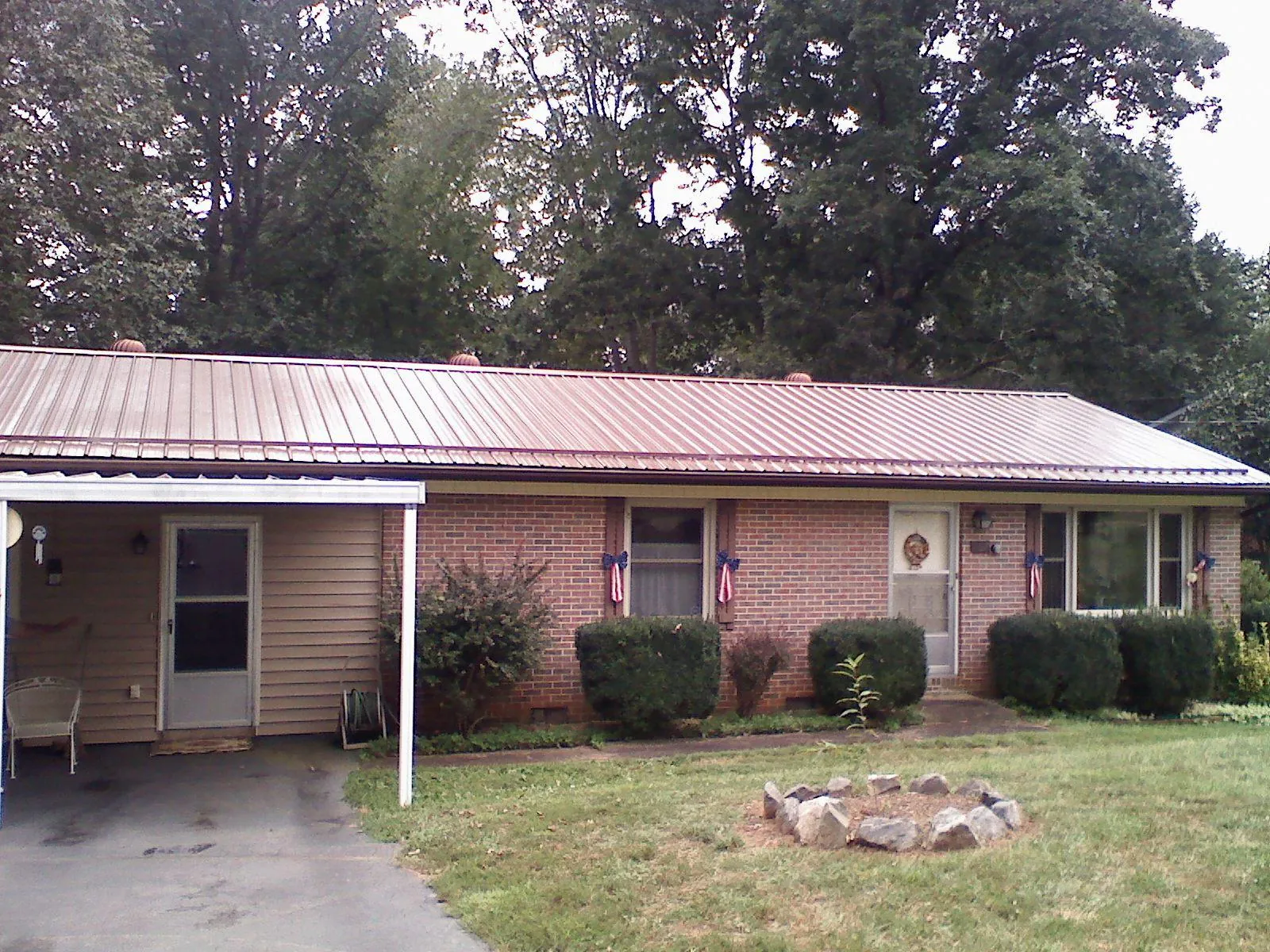Bronze metal roof and carport on a brick ranch home — Roof Repair work by our crew in Wilbur
